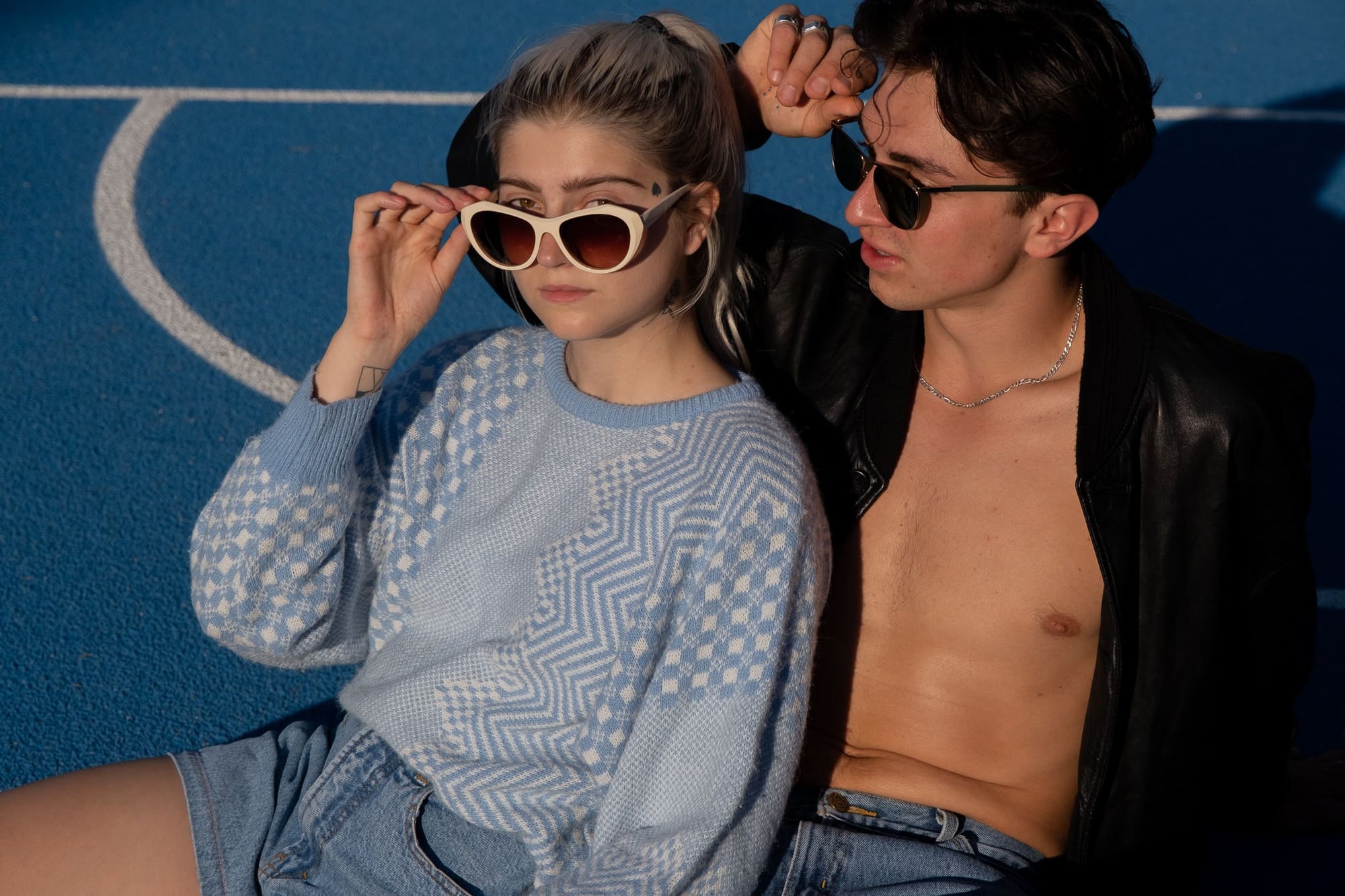Weibliches Model mit Theo by Tim Van Steenbergen Sunglasses in creme und männliches Model oben ohne.