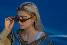 Laden Sie das Bild in den Galerie-Viewer, Weibliches Model mit Vintag Knit Cardigan und schmaler cooler Sonnenbrille.