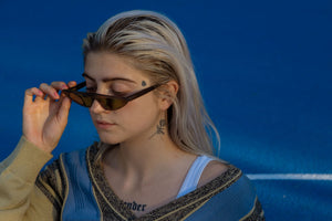 Weibliches Model mit Vintag Knit Cardigan und schmaler cooler Sonnenbrille.
