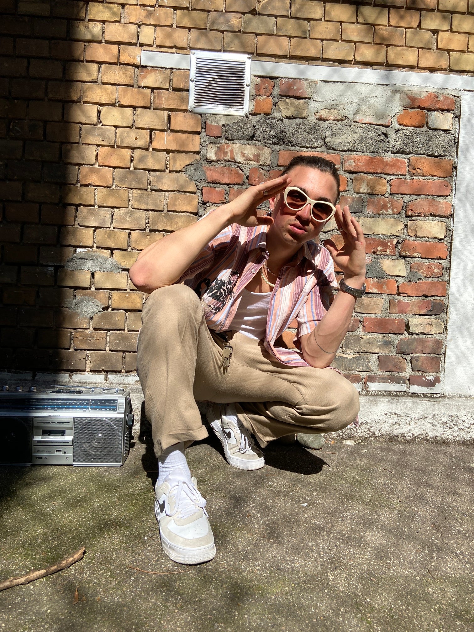 Tragebild der Theo by Tim Van Steenbergen Sunglasses Creme vor Backstein Hintergrund.