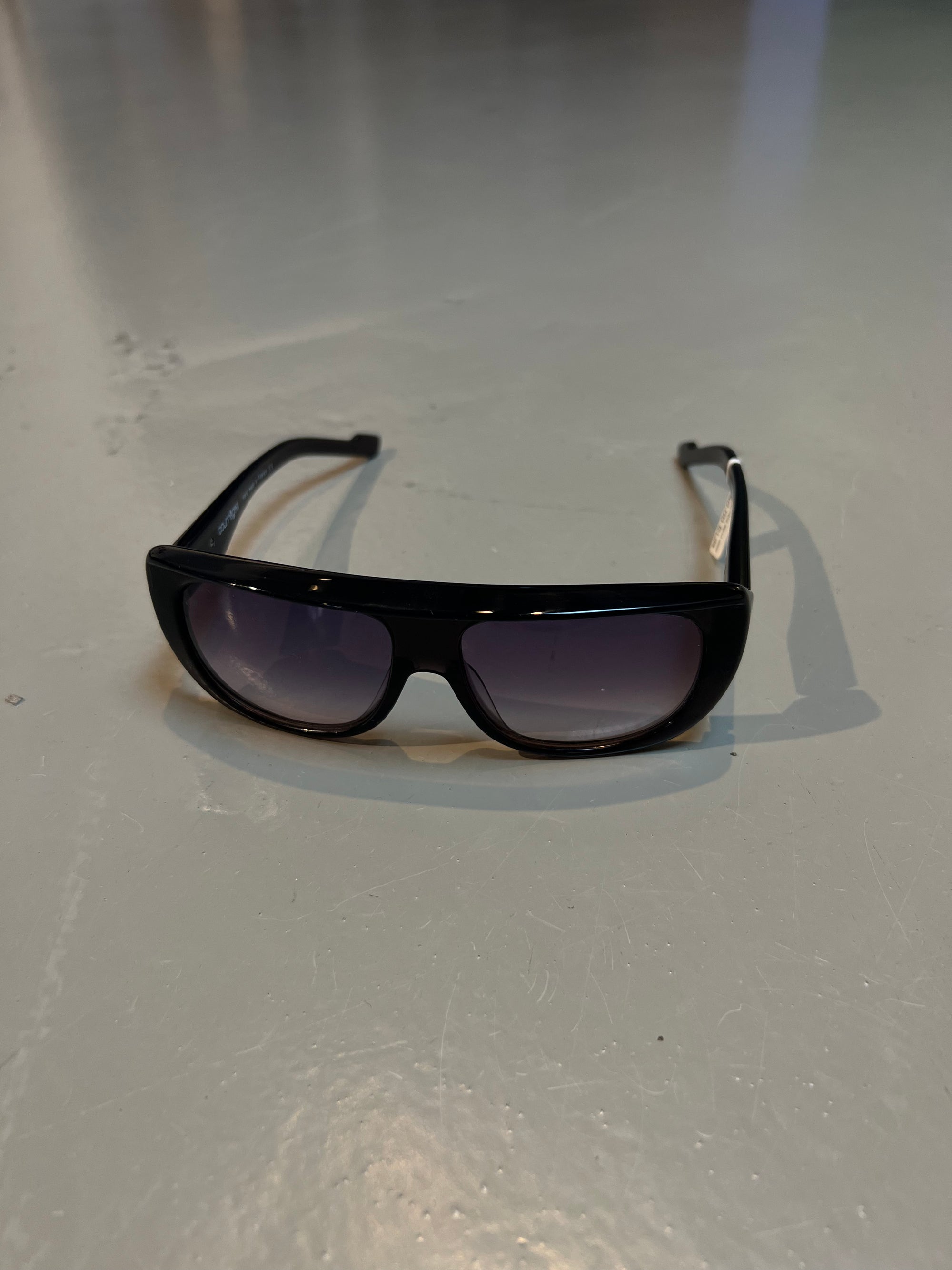 Produktbild einer Alain Mikli Paris Sonnenbrille vor grauem Hintergrund.