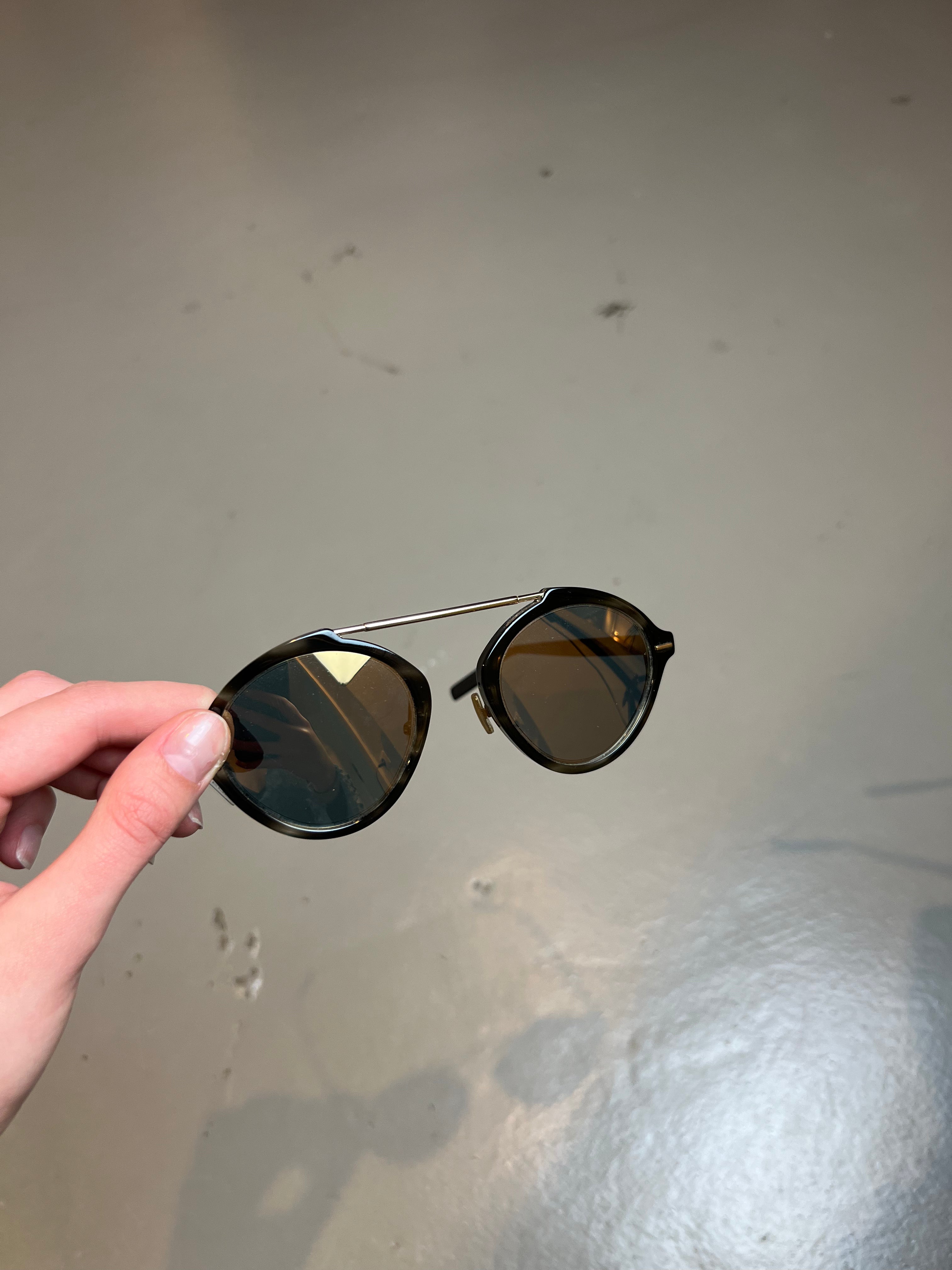 Produktbild einer Christian Dior Sonnenbrille vor grauem Hintergrund.