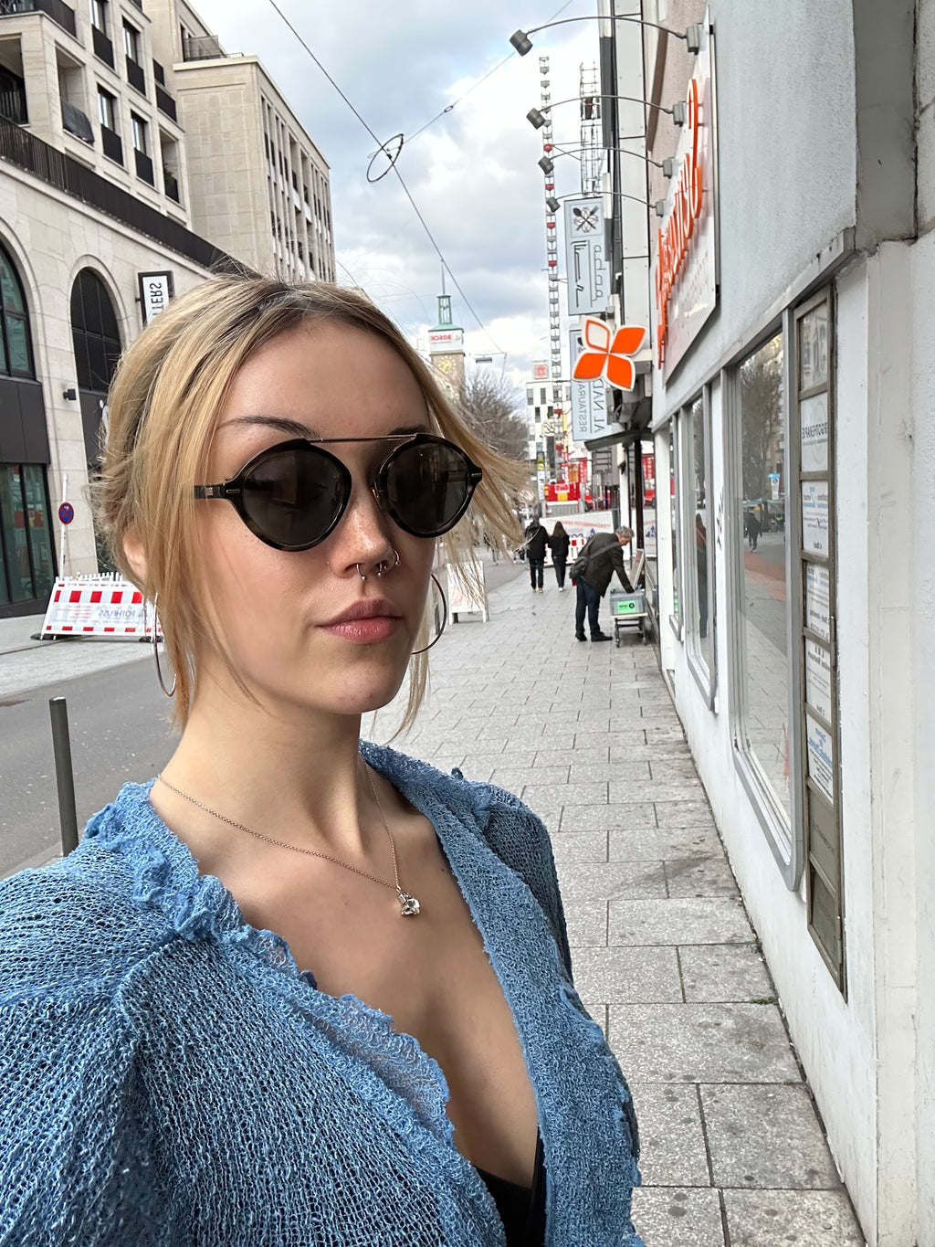 Tragebild einer Christian Dior Sonnenbrille vor städtischer Kulisse.