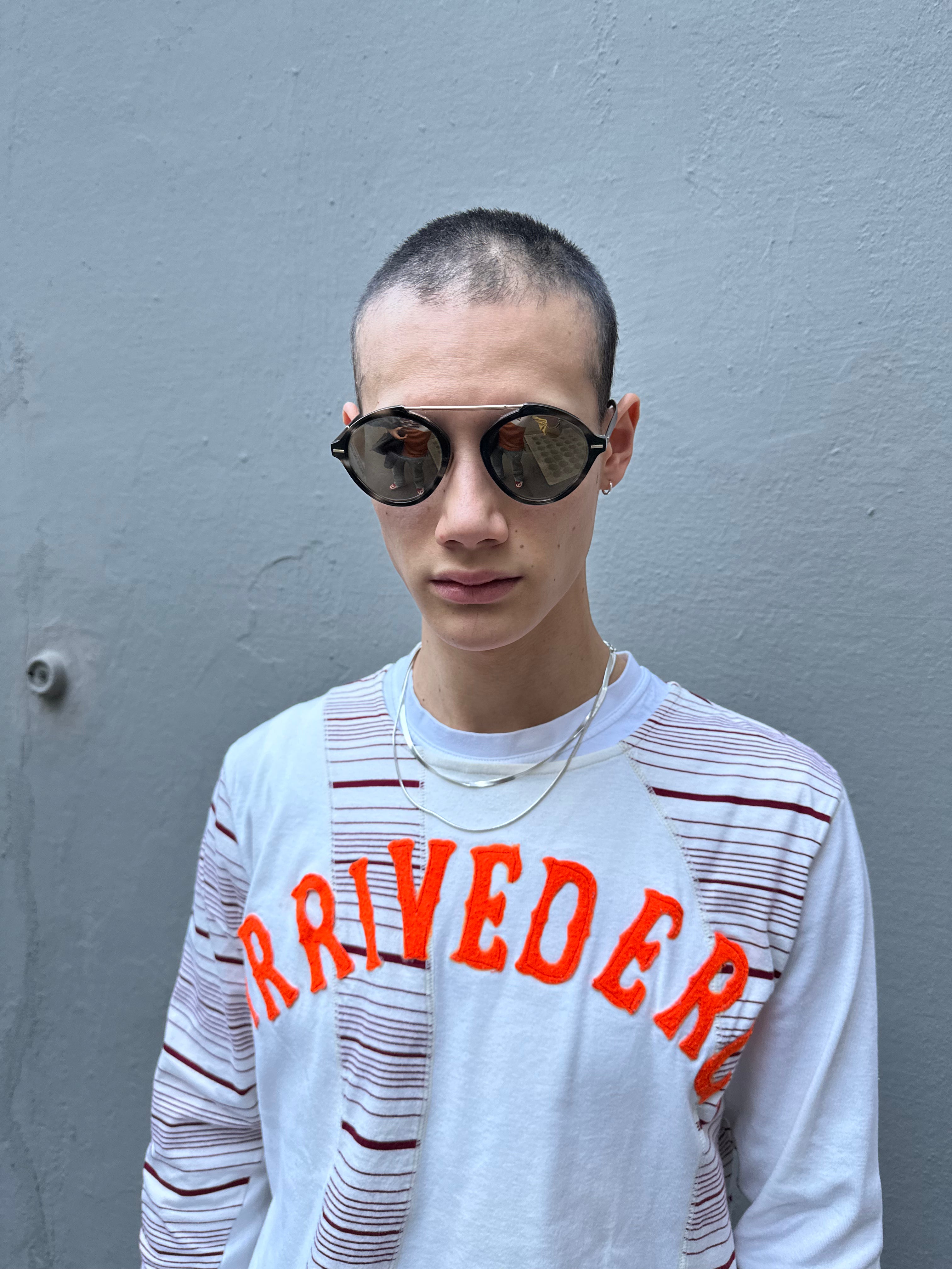 Tragebild einer Christian Dior Sonnenbrille vor grauem Hintergrund.