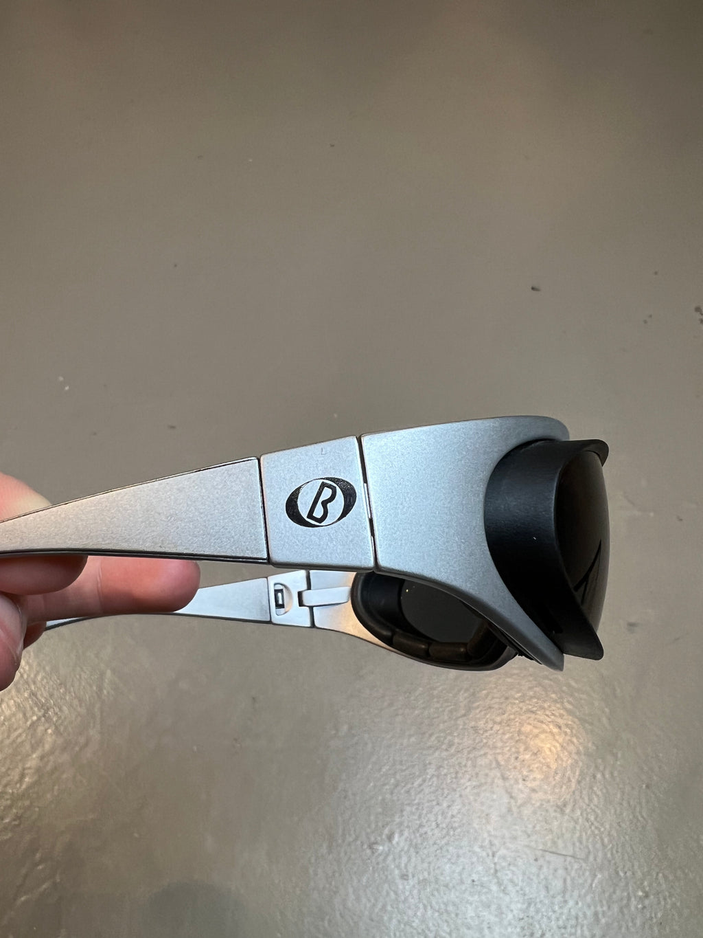 Detail-Produktbild von einer Baruffaldi Y2K Sonnenbrille vor grauem Hintergrund.